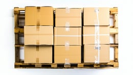 Photorealistic topdown view of a perfectly packed pallet on a white background showing uniform interlocking boxes stacked efficiently Use shadow and depth to emphasise Tetrislike precision Include subtle details like pallet edges or strapping for rea